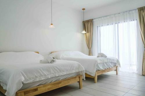 a bedroom with two beds and a window at Comfy Sofy 23- Balcony Garden (Night market) in Tanah Rata