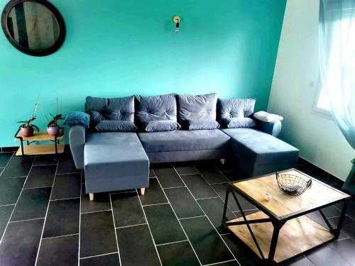 a living room with a blue couch and a table at Entre Nous in Vironchaux