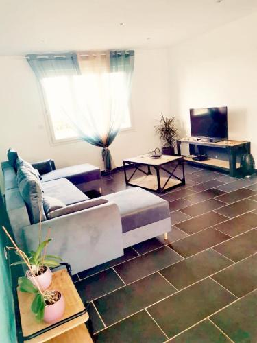a living room with a couch and a tv at Entre Nous in Vironchaux