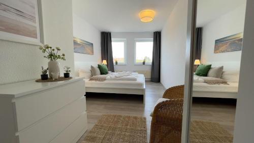 a living room with two beds and a window at Strandhaus-Nordseebrandung-Fewo-A2-4 in Cuxhaven