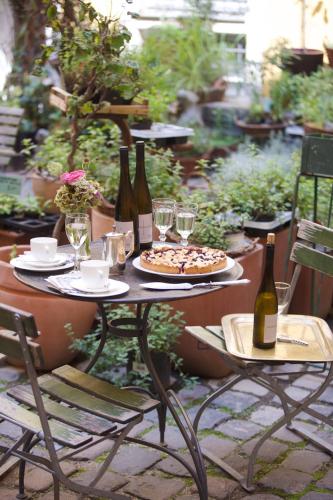 a table with two bottles of wine and a pizza at Hotel Fregehaus in Leipzig