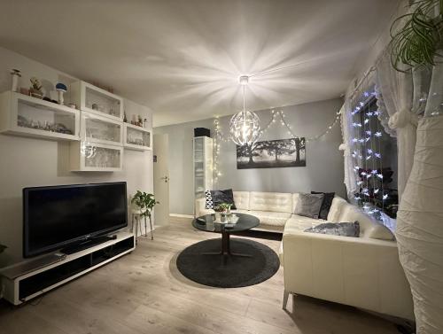 a living room with a white couch and a tv at Central and cozy next to Oslo S in Oslo