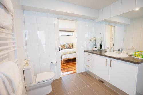 een witte badkamer met een toilet en een wastafel bij Luxurious 4 Bedroom House with Stunning Beach view in St Leonards in Saint Leonards