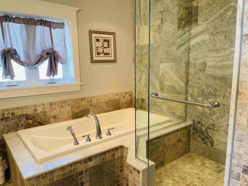 W łazience znajduje się wanna i przeszklony prysznic. w obiekcie SouthLake Cottage on The Lake. w mieście Washago