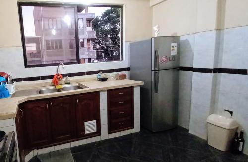 a kitchen with a sink and a refrigerator at La Casita Feliz...!!! in Cochabamba