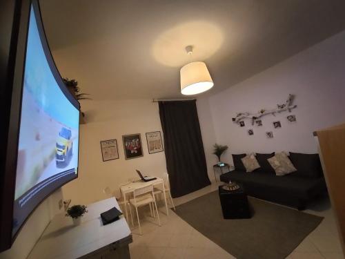 ein Wohnzimmer mit einem Sofa und einem großen TV in der Unterkunft Cavour Home in Trient