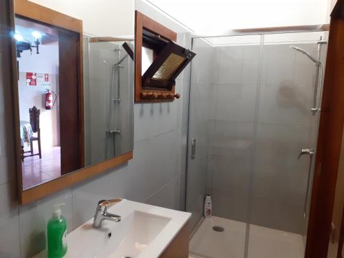 a bathroom with a sink and a shower with a mirror at Casa de Santa Luzia B in Caminha