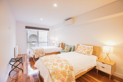 een slaapkamer met 2 bedden en een raam bij Luxurious 4 Bedroom House with Stunning Beach view in St Leonards in Saint Leonards