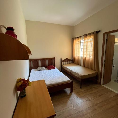 a small bedroom with a bed and a table at Sítio Sonho da Vovó in Esmeraldas