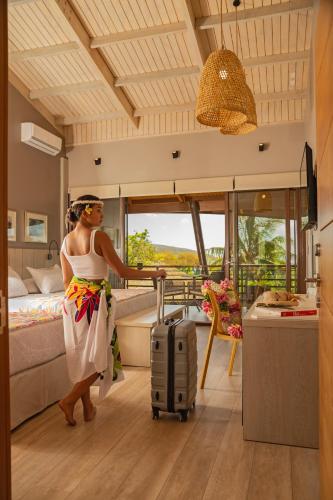 a woman with a suitcase in a hotel room at Hotel Ohana Rapa Nui in Hanga Roa