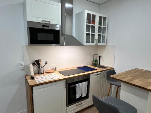 a small kitchen with white cabinets and a counter at Studio Climatisé Centre Ville #9 in Toulon