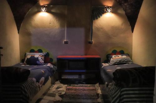 Habitación con 2 camas y luces en la pared en Carmah Guest house en Asuán