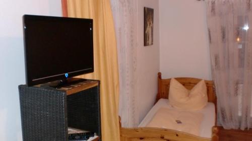 a television sitting on top of a stand in a room at Landgasthof zum Brückenwirt in Starnberg