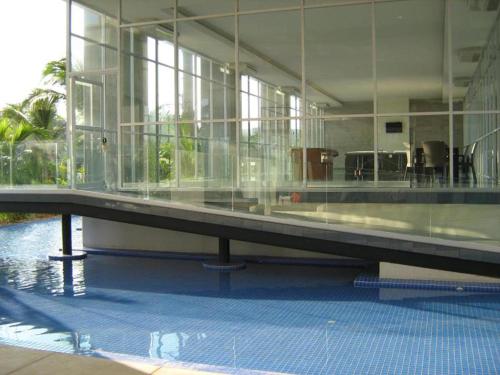 a large building with a swimming pool with glass walls at Apartamento Acapulco Diamante - Condominium Aura in Acapulco
