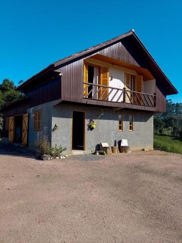 a house with a balcony on the side of it at Pousada Canever in Lauro Müller