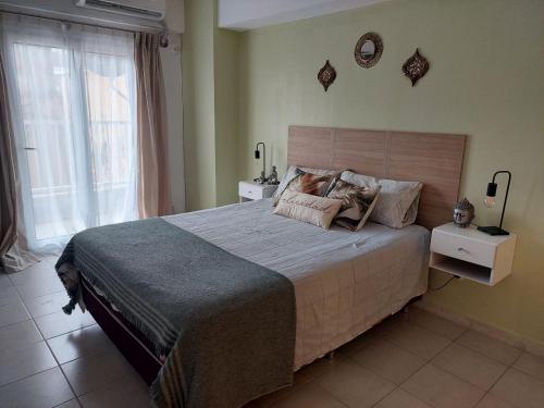 1 dormitorio con cama grande y ventana grande en Muriel en San Miguel de Tucumán
