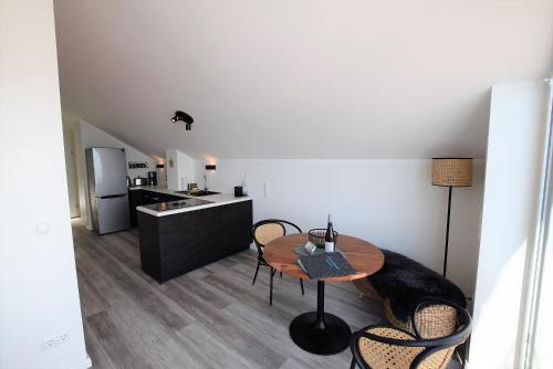 een keuken en eetkamer met een tafel en stoelen bij Meeresblick-Strandkieker-Haus-3-WE-45 in Hohwacht