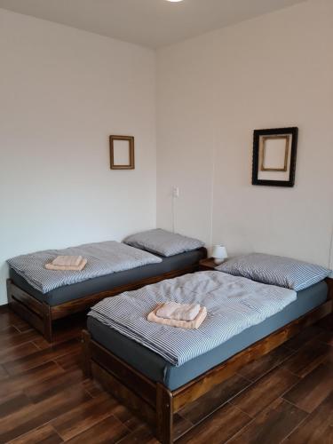 two twin beds in a room with wooden floors at La Casa Rosa in Nová Baňa