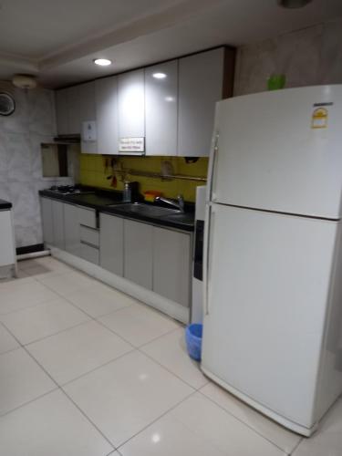 a kitchen with a white refrigerator in a room at Cozy House in Incheon