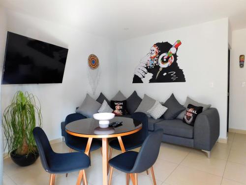 a living room with a couch and a table and chairs at #1 Cozy depa Aeropuerto Estadio GNP -Foro Sol- in Mexico City