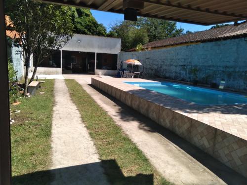 Un patio trasero con piscina y una casa. en Casa com Piscina Privativa em Bertioga 2 Suítes e Wi-Fi Bem próxima à praia, en Bertioga