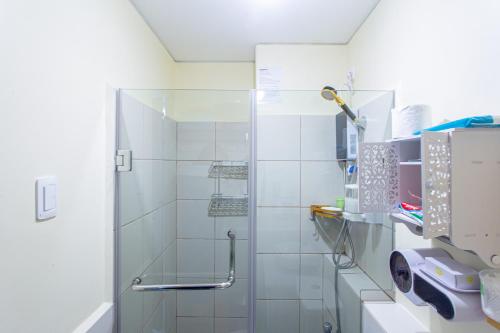 a shower with a glass door in a bathroom at Pandora's Nest in Manila