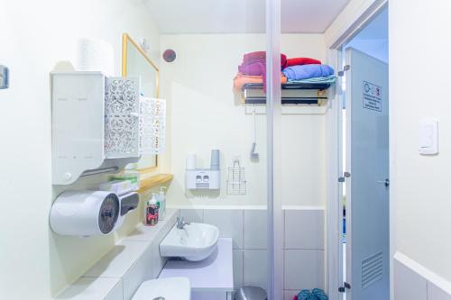 a white bathroom with a sink and a toilet at Pandora's Nest in Manila