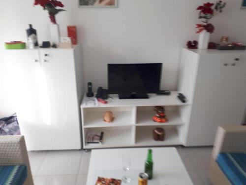 a living room with white cabinets and a tv at Tree Bies Resort Subaúma - Apartamento particular in Subaúma
