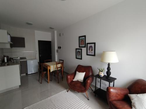 een woonkamer met een bank, stoelen en een tafel bij Departamento boutique en Salta in Salta