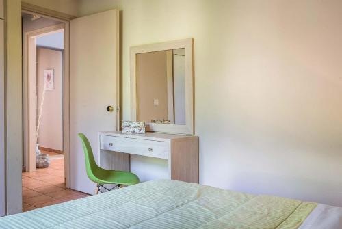 1 dormitorio con cama, escritorio y espejo en Marina en Trapezaki