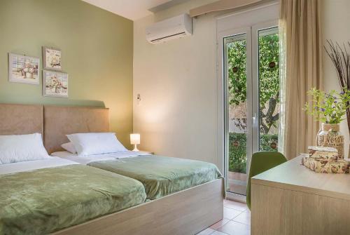 1 dormitorio con 2 camas, ventana y escritorio en Marina en Trapezaki