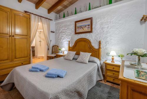 a bedroom with a bed with two blue towels on it at Bon Redos in Pollença