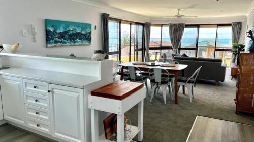 una cucina e un soggiorno con tavolo e sala da pranzo di A Minutes Walk To The Beach! a Caloundra