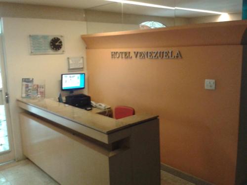 an office with a reception desk with a sign on the wall at Hotel Venezuela in Rio de Janeiro