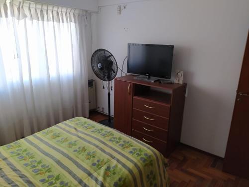 Dormitorio con cama y tocador con TV en Departamento en Mar del Plata, excelente ubicación, pleno centro, 3 habitaciones. en Mar del Plata