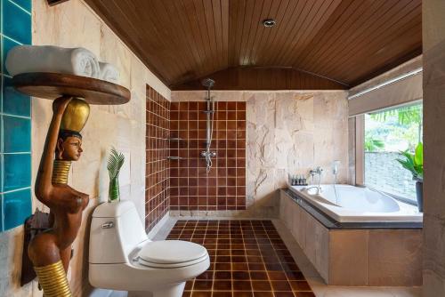 a bathroom with a toilet and a tub and a sink at Panviman Resort Koh Phangan in Thong Nai Pan Noi