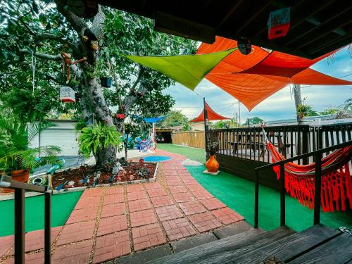 a backyard with a playground with a tree and an umbrella at Hammocks & mini-golf! 10 mins from Beach! in Hollywood