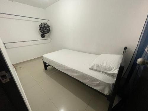 Apartamento en santa marta donde jesus 2 في سانتا مارتا: غرفة نوم صغيرة مع سرير مع ملاءات بيضاء
