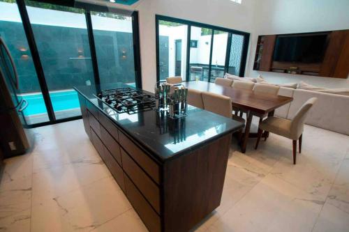 una cucina con piano cottura e un soggiorno di Casa Moderna de 4 Pisos Con Rooftop Vista Al Mar a Isla Mujeres
