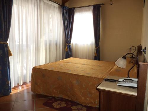 a bedroom with a bed with a desk and a window at Hotel Cà Fiore in Bardonecchia