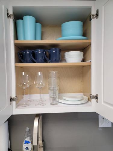a kitchen cabinet with plates and glasses and a sink at 3509 Luxury Location and Location in Orlando