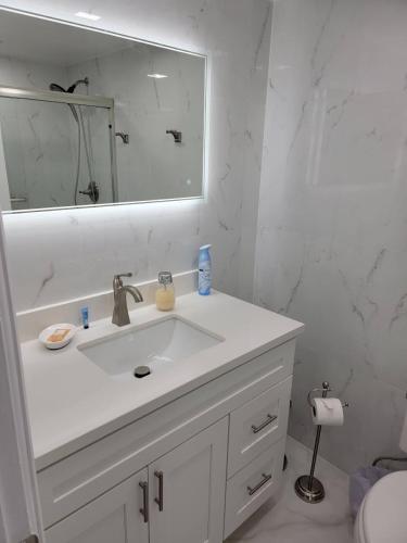 a white bathroom with a sink and a mirror at 3509 Luxury Location and Location in Orlando