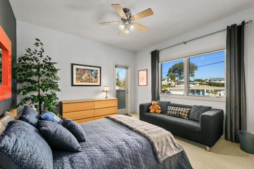 a bedroom with a bed and a couch and a window at 4000 sq ft Resort Home Near Carlsbad Beaches! in Carlsbad
