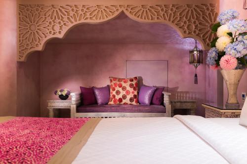 a bedroom with a bed and a pink wall at Kenting Amanda Hotel in Nanwan