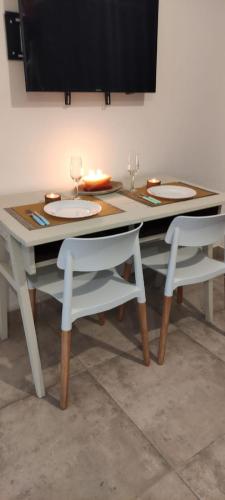 mesa de comedor con 2 sillas y 2 copas de vino en Mono Chancas en Vaqueros