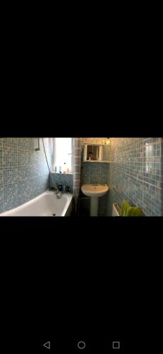 a bathroom with a tub and a sink and a bath tub at Nice Shared Flat in London