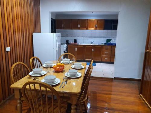 a kitchen with a wooden table with chairs and a dining room at Spacious 4-bdrm fully self-contained WIFI, Parking in Suva