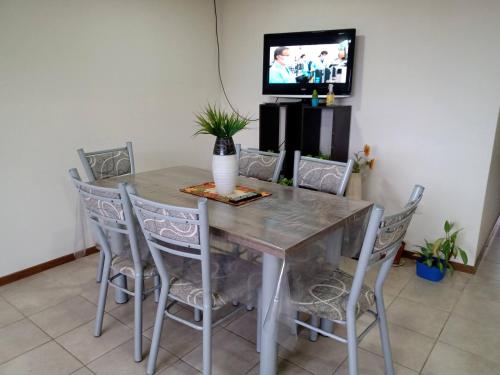 un tavolo da pranzo con sedie e una TV di Calido alojamiento a Ushuaia