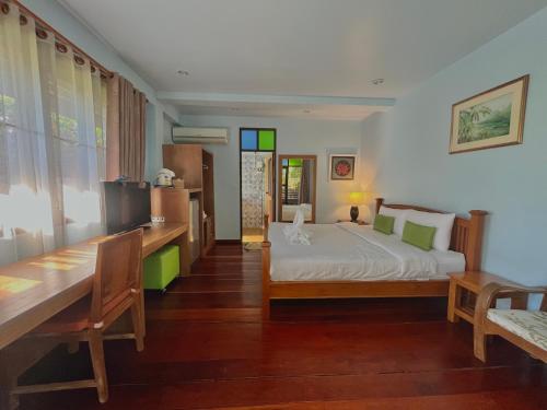 a bedroom with a bed and a table and chairs at Baan Pai Nai Wieng in Pai
