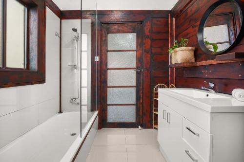 ein Bad mit einem Waschbecken, einer Dusche und einem Spiegel in der Unterkunft Coronet Spa Retreat in Corinella